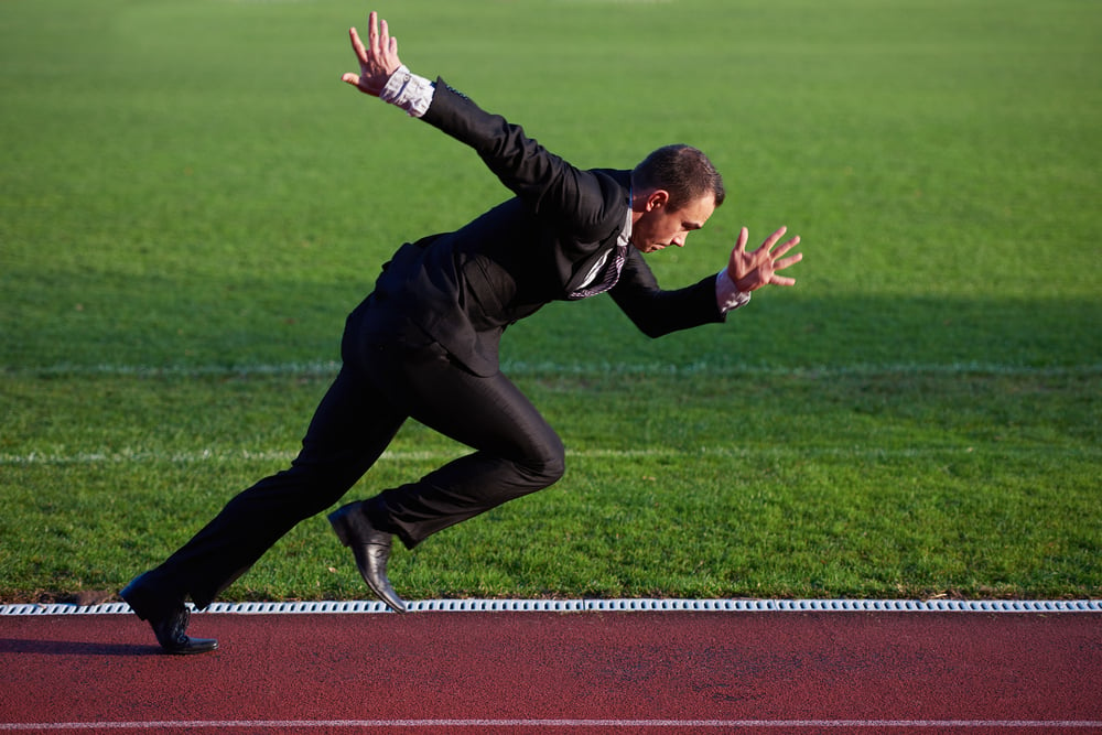 business man in start position ready to run and sprint on athletics racing track